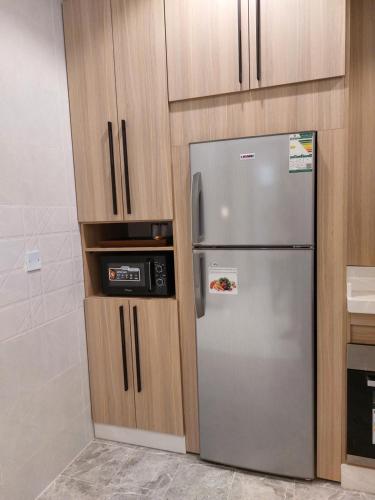 塔伊夫Elite House的厨房配有不锈钢冰箱和木制橱柜