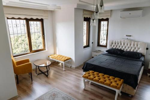 阿拉尼亚Yıldız Villa的一间卧室配有一张床、一把椅子和窗户。