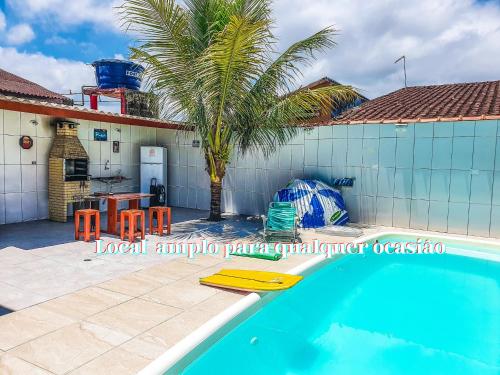 蒙加瓜Casa Do Mar - Wi-fi - Netflix - Piscina的一座带游泳池和棕榈树的房子