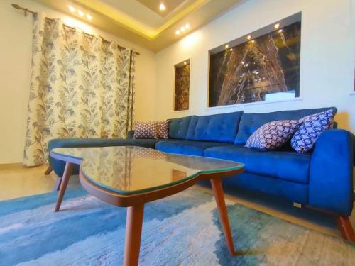 亚历山大Join Inn Apartments的客厅配有蓝色的沙发和玻璃桌