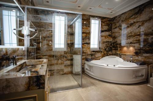 斯库台Ervini Boutique Hotel的大型浴室设有浴缸和淋浴。