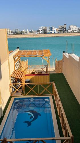 杜拉特阿拉尔درة العروس اكواخ الدره的一座游泳池位于一座享有海景的建筑的顶部
