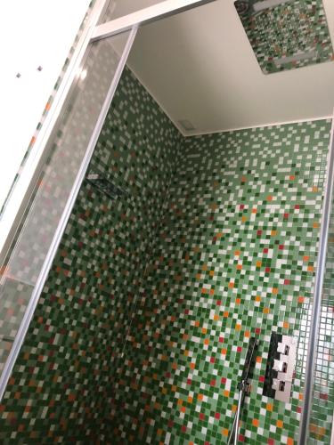 卡斯泰拉马莱COCCIU D’AMURI的浴室拥有绿色和棕色的瓷砖墙