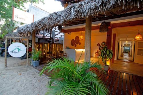 杰里科科拉Pousada Nativa Jeri的海滩上带稻草屋顶的餐厅