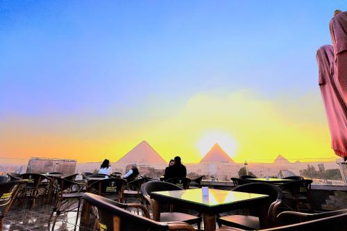 开罗MagiC Pyramids INN的一群坐在桌子旁看金字塔的人