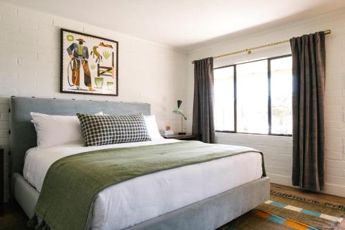 佩索罗伯斯River Lodge Paso的一间卧室设有一张大床和一个窗户。