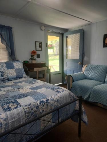 ShaftsburySerenity Motel的一间卧室配有一张床、一张沙发和一个窗口