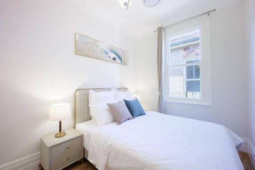 悉尼Cosy Federation Apartment Kirribilli 4 Bedroom的白色的卧室设有白色的床和窗户。