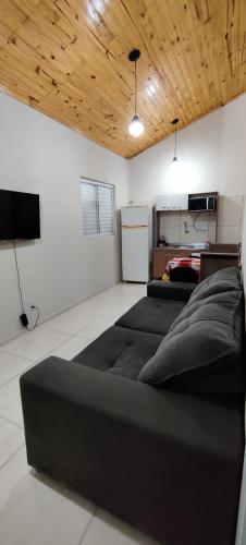 圣安热卢Apartamento modelo chalé 201的客厅配有黑色沙发和电视
