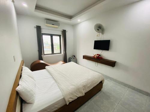 太原省Khách sạn Phú Hưng的一间卧室配有一张床和一台电视
