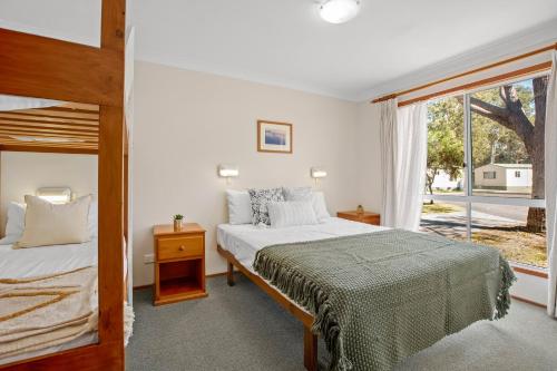 KioloaTasman Holiday Parks - Kioloa Beach的一间卧室设有两张床和大窗户