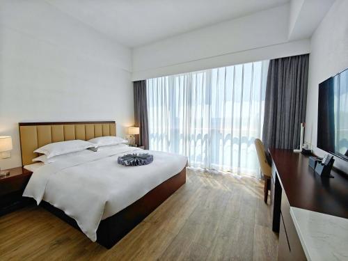 北京北京明珠酒店(北京大兴机场店)的一间卧室设有一张大床和一个大窗户
