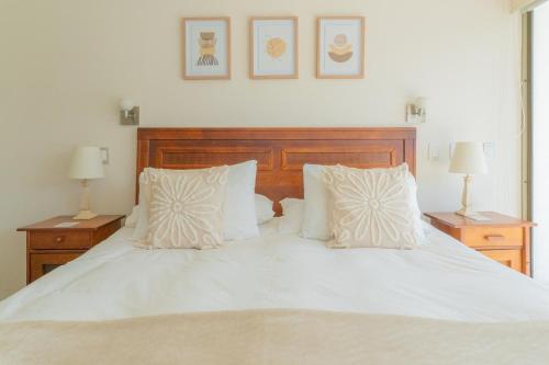 圣地亚哥Kennedy Premium Apartments的一张带两个枕头和两盏灯的白色床