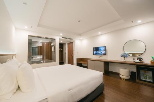 河内Love St - Hanoi Hotel的卧室配有一张白色大床和一张书桌