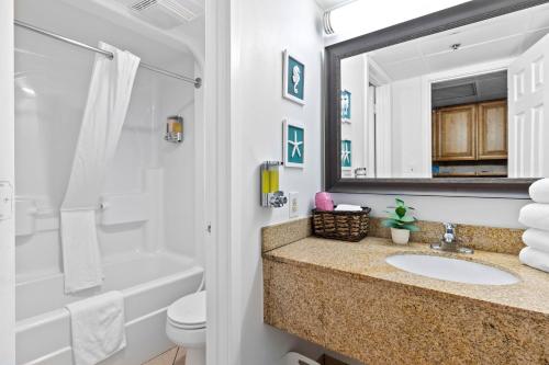 默特尔比奇Oceanfront Oasis的一间带水槽、浴缸和镜子的浴室