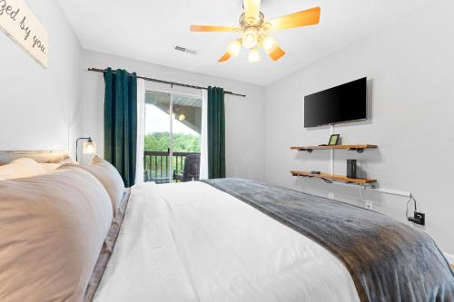 布兰森Lizzy's Landing的一间卧室配有一张带吊扇的床和一台电视。