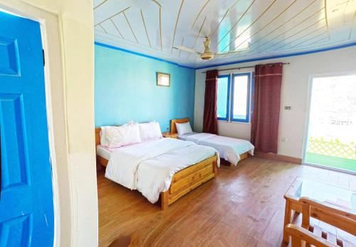 锡卡都Hotel Mountain Lodge Skardu的蓝色墙壁客房的两张床