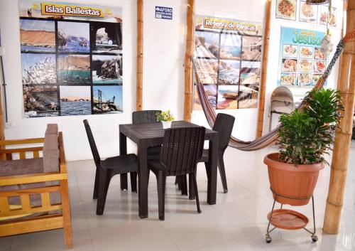 帕拉卡斯Hospedaje El Buen Samaritano的一间用餐室,配有黑色的桌子和椅子