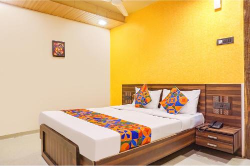 浦那FabExpress Gargi Executive的一间卧室设有一张床和黄色的墙壁