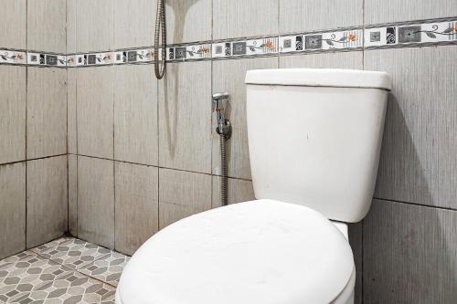 BangkoRedDoorz @ Hotel Keluarga Bangko的带淋浴的浴室配有白色卫生间