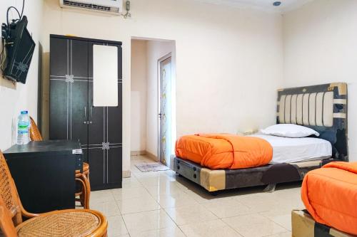 BangkoRedDoorz @ Hotel Keluarga Bangko的一间卧室配有两张床和一张桌子及椅子