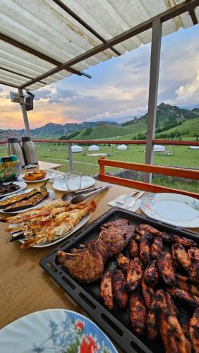 NalayhMagic Rock Tourist Camp的餐桌上放有食物和肉盘的桌子