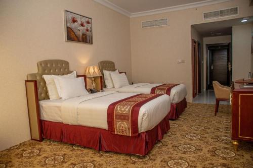 阿尔布亚米Al Salam Grand Hotel & Resort的酒店客房配有两张床和一张书桌
