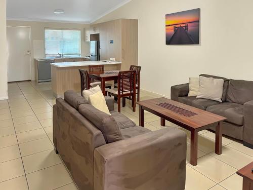 埃默拉尔德Direct Collective - Villas on Rivergum的客厅配有沙发和桌子