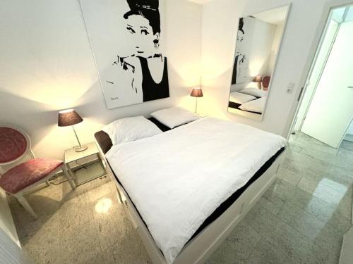 蒂门多弗施特兰德- Bel Etage - Bergstrasse 35的卧室配有一张白色大床和镜子