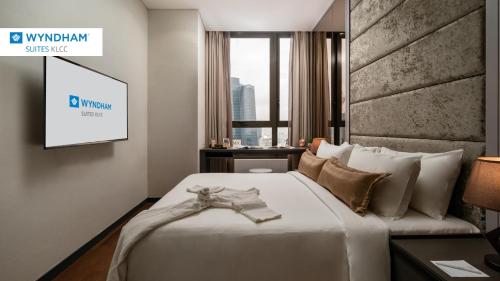 吉隆坡Wyndham Suites KLCC的一间酒店客房,配有一张床和一台电视