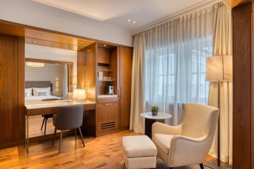 圣莫里茨Grand Hotel des Bains Kempinski的酒店客房,配有一张床、一张桌子和椅子