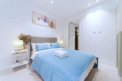 墨尔本普瑞德福克纳海湾景公寓（六十二号）的白色卧室配有蓝色床单