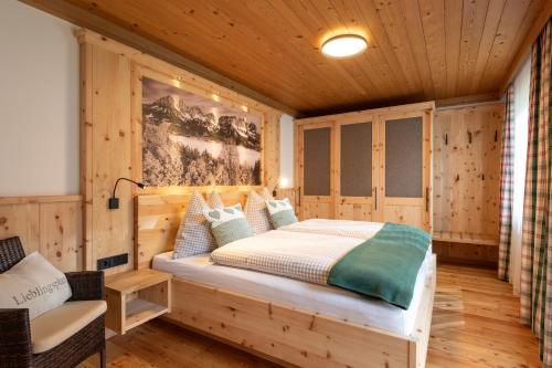 埃尔毛Landhaus Horngacher的木制客房内的一间卧室,配有一张床