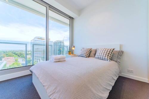 墨尔本湾景5号福克纳公寓的一间卧室设有一张床和一个大窗户