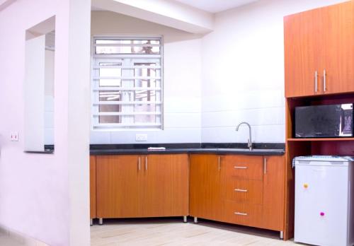 拉各斯Crib 6的厨房配有木制橱柜、水槽和窗户。