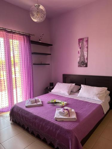 瓦里Eva’s House的一间卧室配有一张紫色床和毛巾