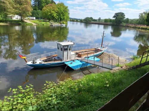 格里马Ferienwohnungen Grimma 3的一艘小船停靠在河上