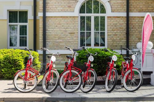 德鲁斯基宁凯Europa Royale Druskininkai的停在大楼前的一群红色自行车