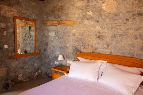伊罗达Pappou's Traditional Cottage at Epano Elounda的一间卧室设有一张床和石墙