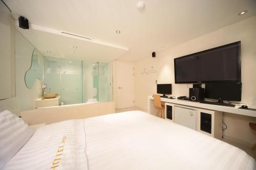 首尔Jongno Hotel Pop Leeds Premier的一间卧室配有一张床和一台平面电视