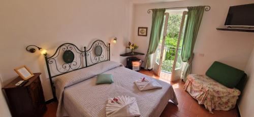 莱万托Hotel La Giada del Mesco的卧室配有床、椅子和窗户。