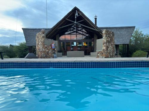 兰斯堡Morokolo Safari Lodge Self-catering的大楼前带游泳池的房子