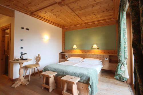 科尔蒂纳丹佩佐Ciasa Vervei的一间卧室配有一张大床和一张桌子