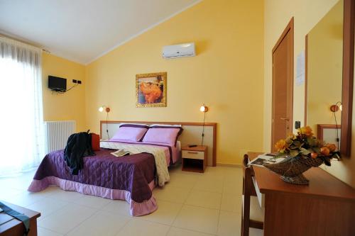 圣乔瓦尼·罗通多卡萨奥格罗住宿加早餐旅馆的一间卧室配有一张带紫色床单的床和一张桌子
