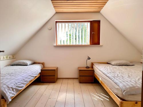 KrüüdneriKrüüdneri puhkemaja的阁楼卧室设有两张床和窗户。