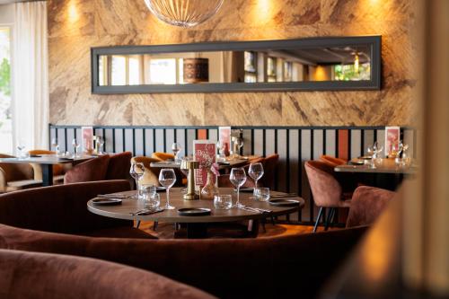 博黑克Hotel Restaurant BEAU的餐厅设有桌椅和镜子