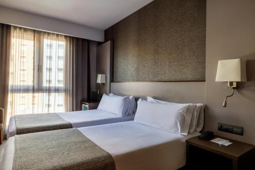 巴塞罗那加泰罗尼亚雅典酒店的酒店客房设有两张床和窗户。
