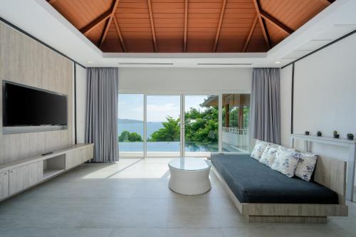 芭东海滩Andamantra Resort and Villa Phuket - SHA Extra Plus的带沙发和电视的客厅