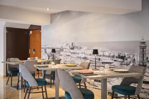 巴塞罗那加泰罗尼亚雅典酒店的用餐室配有桌椅和壁画