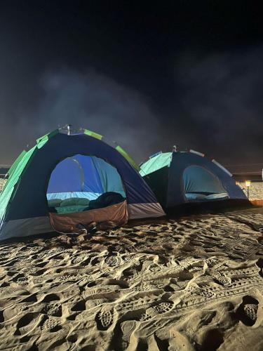 HunaywahDubai Tourism and Travel Services的沙滩上的两个帐篷